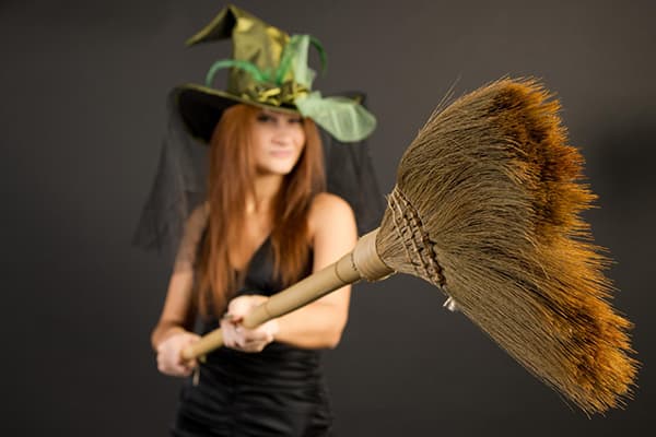 Girl dalam kostum penyihir dengan penyapu