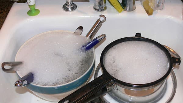 Oppvasken blir gjennomvåt i en vaskemiddelløsning