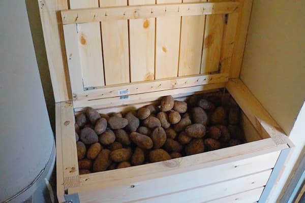 En låda med potatis på balkongen