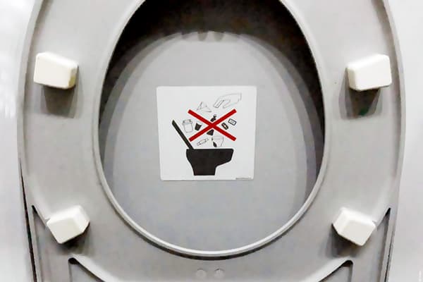 Aufkleber, der das Werfen des Abfalls in die Toilette verbietet