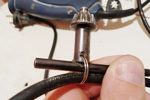 Upevnenie kľúča od vŕtačky k drôtu pomocou kovového krúžku