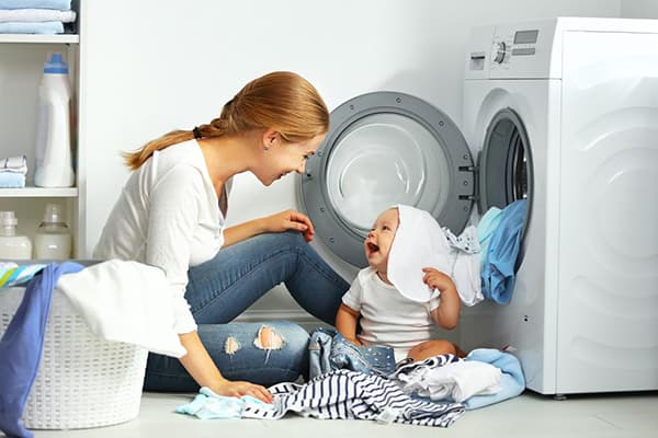Mama und Baby nehmen Kleidung auseinander, nachdem sie sich gewaschen haben