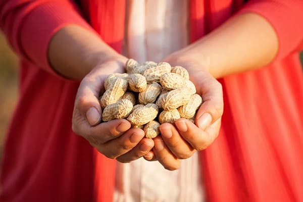 Kvinna med en handfull jordnötter
